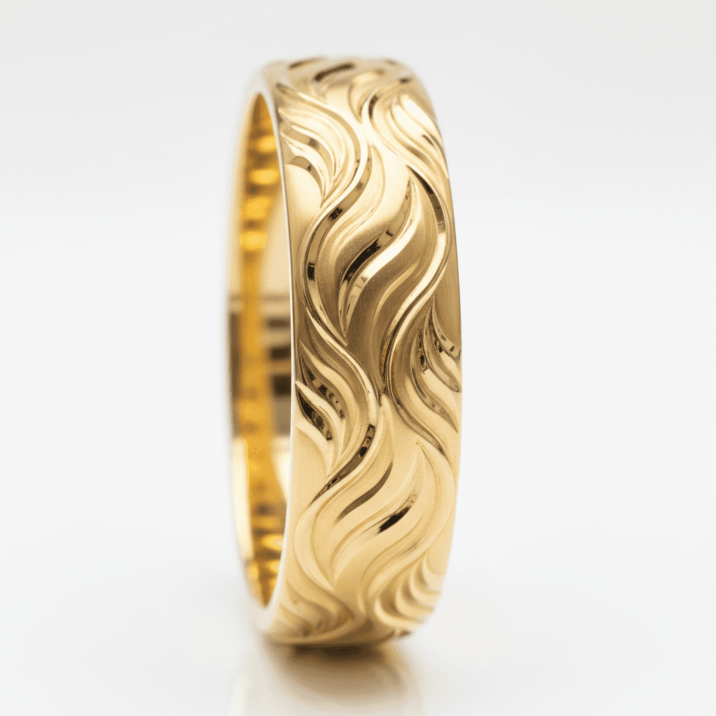 Wide yellow gold band ring with engraved flowing flame pattern encircling the surface