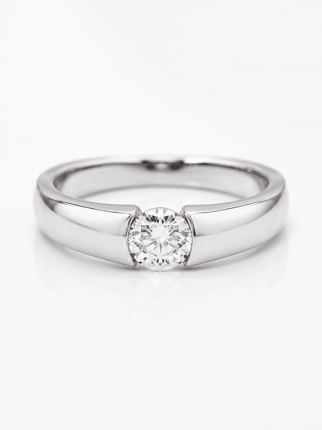 Polished white gold solitaire ring with round brilliant diamond in half-bezel setting